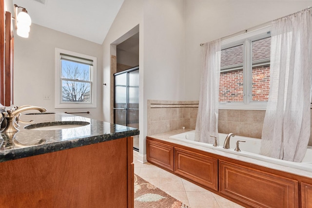 bathroom with tile patterned flooring, vanity, vaulted ceiling, a shower stall, and a bath