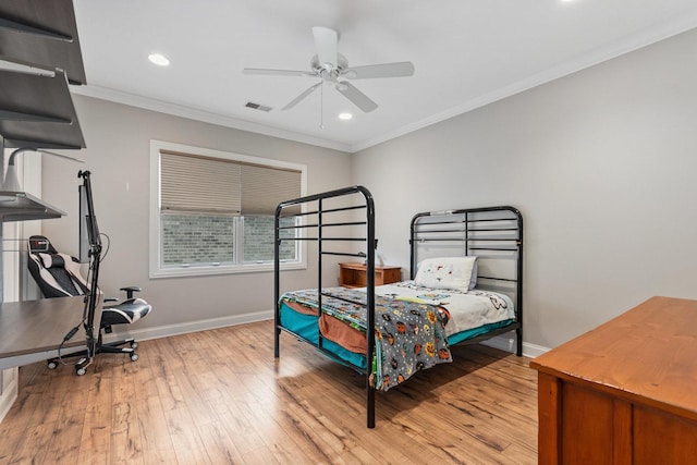 bedroom featuring visible vents, crown molding, light wood-style flooring, and baseboards
