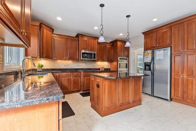 kitchen featuring tasteful backsplash, a kitchen island, stainless steel appliances, and a sink