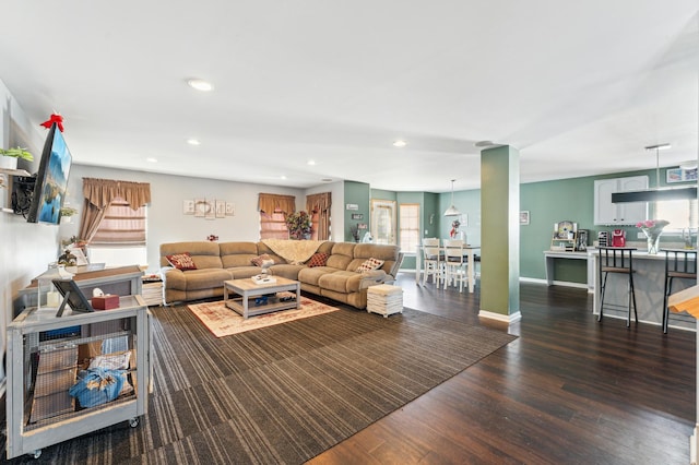 living area featuring baseboards, wood finished floors, and recessed lighting