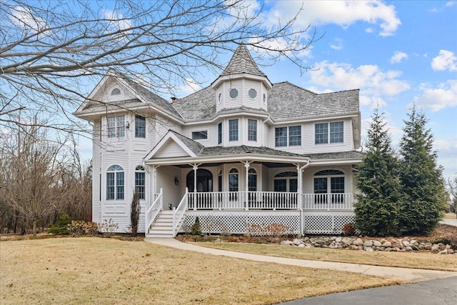 victorian home featuring covered porch and a front yard