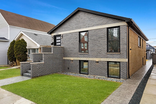 view of front of home featuring brick siding and a front yard