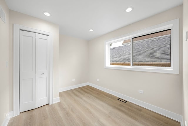 unfurnished bedroom featuring light wood-style floors, recessed lighting, a closet, and baseboards