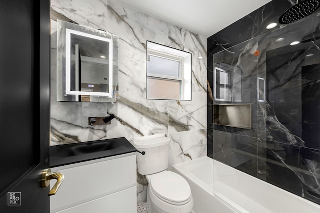 full bathroom with tile walls, toilet, vanity, and a marble finish shower