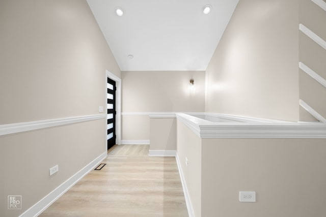 corridor featuring lofted ceiling, light wood finished floors, recessed lighting, and baseboards