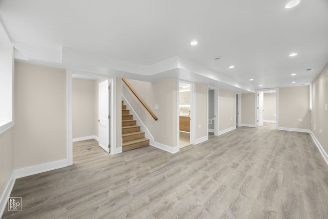 finished below grade area with light wood-style flooring, recessed lighting, stairway, and baseboards