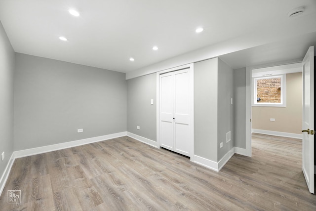 below grade area with light wood-type flooring, baseboards, and recessed lighting