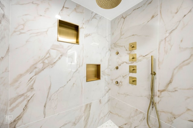 bathroom featuring a marble finish shower