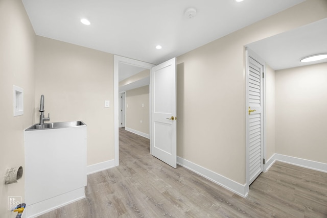 laundry room with light wood-style flooring, baseboards, a sink, and recessed lighting