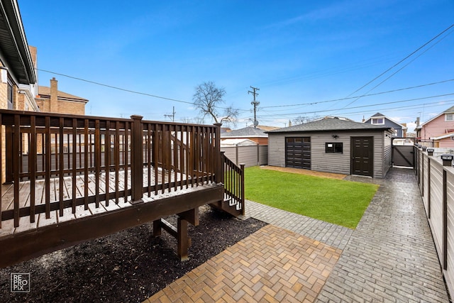 view of yard featuring a fenced backyard, a deck, and an outdoor structure