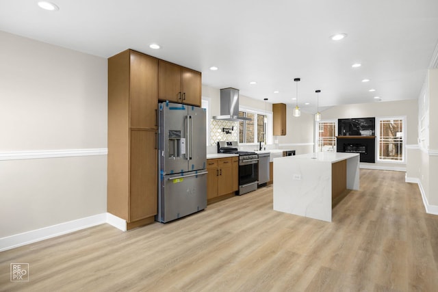 kitchen featuring stainless steel appliances, a kitchen island, light countertops, ventilation hood, and light wood-type flooring