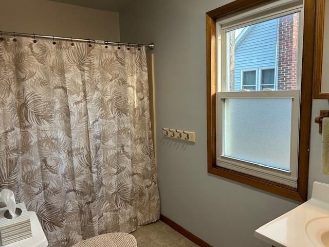 full bathroom featuring curtained shower, vanity, and baseboards