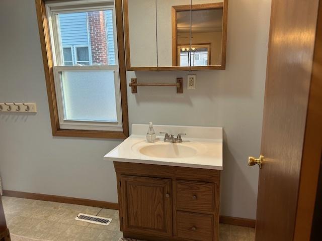 bathroom featuring visible vents, vanity, and baseboards