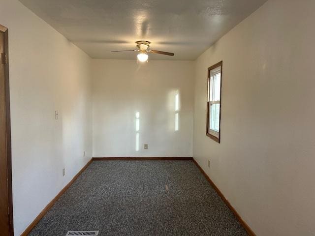 carpeted empty room featuring baseboards and a ceiling fan