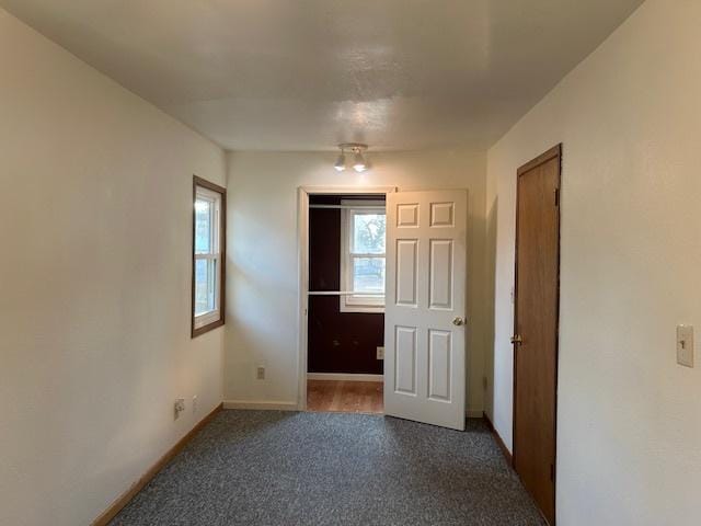 unfurnished room with carpet flooring and baseboards