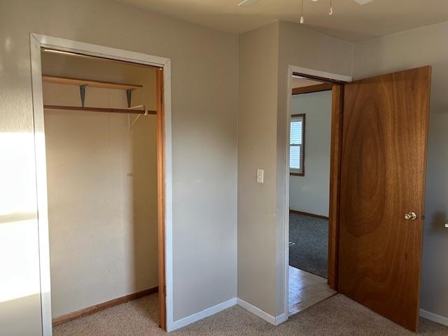 unfurnished bedroom with light colored carpet and baseboards