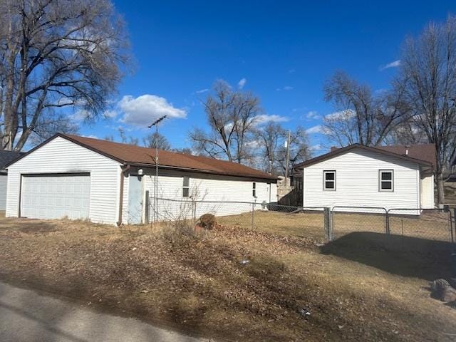 view of home's exterior with a garage and fence