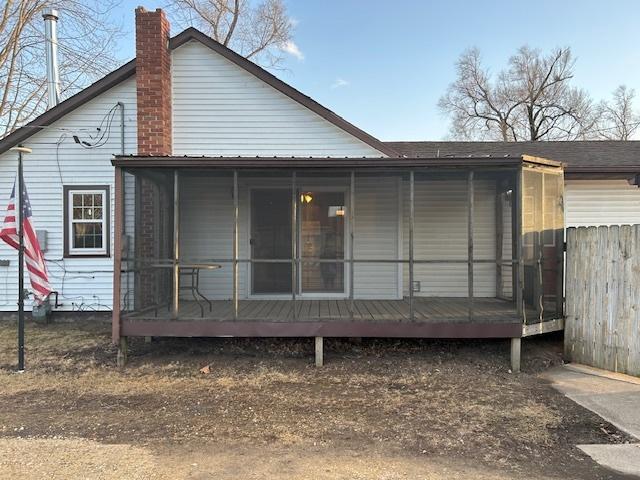 rear view of property featuring a chimney