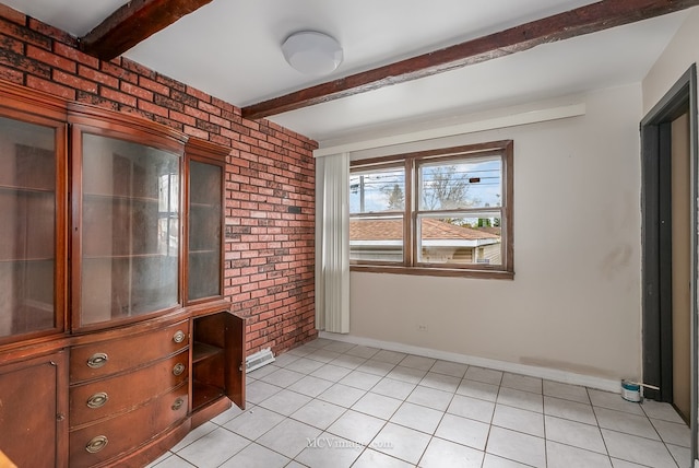 unfurnished room with light tile patterned floors, brick wall, beam ceiling, and baseboards