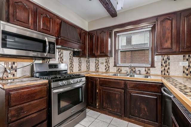 kitchen with custom range hood, appliances with stainless steel finishes, a sink, light countertops, and backsplash