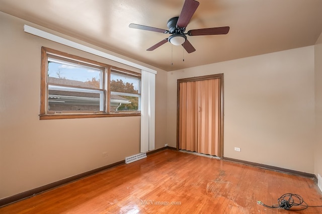 unfurnished room with light wood-type flooring, visible vents, and baseboards