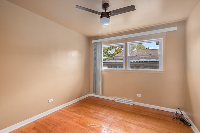 empty room featuring light wood finished floors, baseboards, visible vents, and ceiling fan