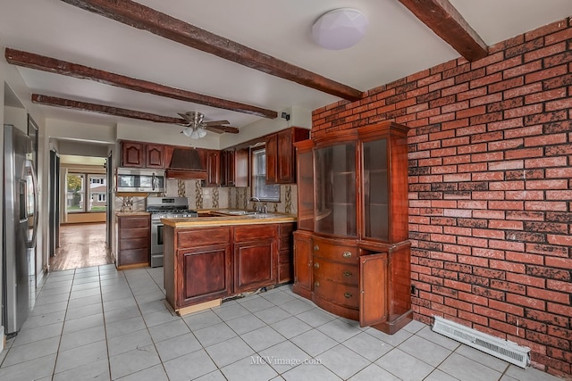 kitchen with brick wall, premium range hood, a peninsula, a sink, and appliances with stainless steel finishes