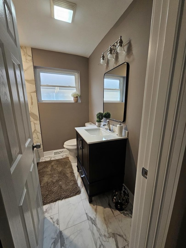 bathroom with marble finish floor, baseboards, vanity, and toilet