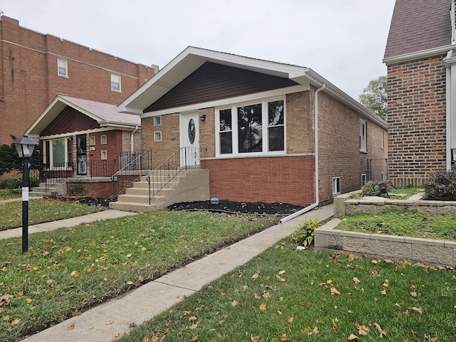 bungalow-style home featuring brick siding and a front lawn