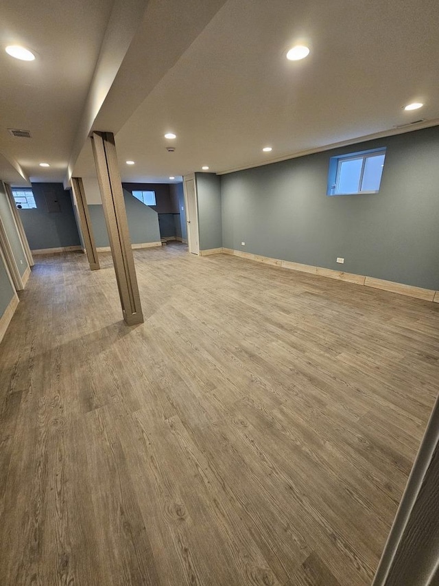 basement with recessed lighting, wood finished floors, visible vents, baseboards, and a wealth of natural light