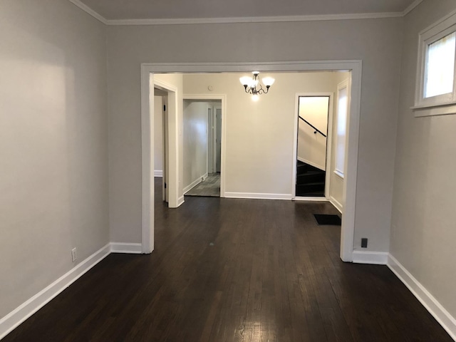 unfurnished dining area with ornamental molding, dark wood-type flooring, a chandelier, and baseboards