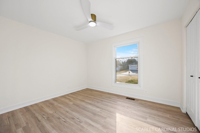 unfurnished room with visible vents, baseboards, and wood finished floors