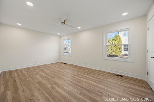 spare room featuring recessed lighting, light wood-type flooring, and baseboards