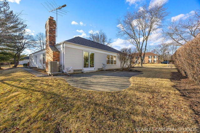 back of house with a patio area, a chimney, central AC, and a yard