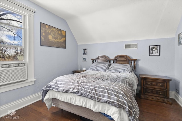 bedroom featuring baseboards, visible vents, vaulted ceiling, and wood finished floors