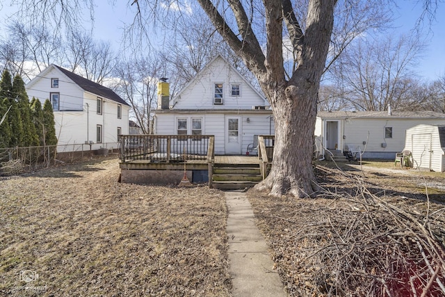 back of property with entry steps, a chimney, fence, and a wooden deck