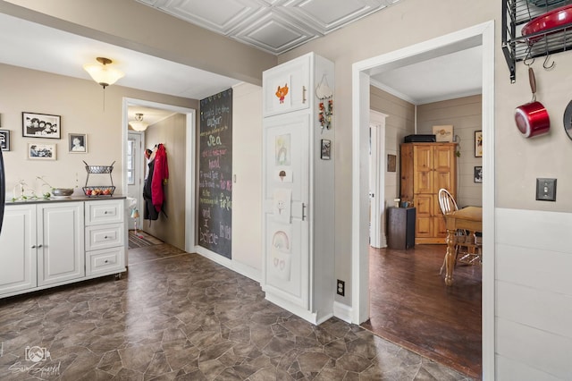 interior space with stone finish floor, an ornate ceiling, and baseboards