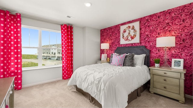 bedroom featuring an accent wall, carpet, baseboards, and wallpapered walls