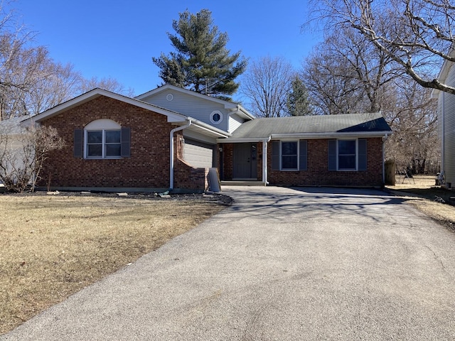 ranch-style house with a garage, brick siding, and driveway