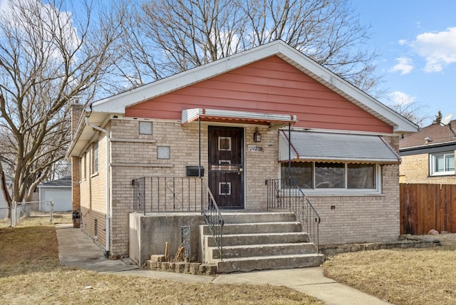 bungalow with brick siding and fence