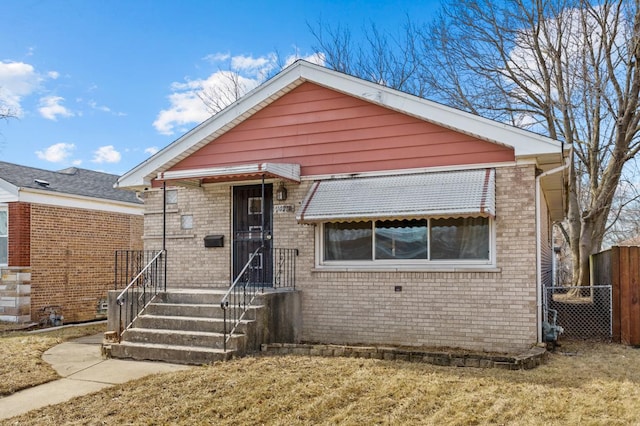 view of front of property with brick siding and fence