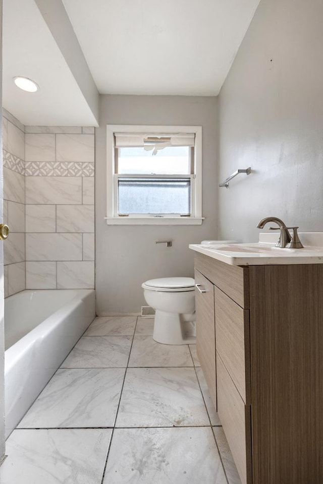 bathroom with marble finish floor, vanity, and toilet