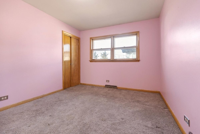 carpeted empty room with visible vents and baseboards