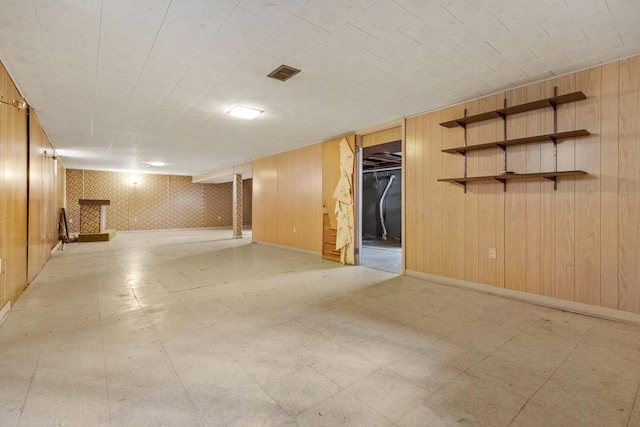 finished basement with light floors, baseboards, and visible vents