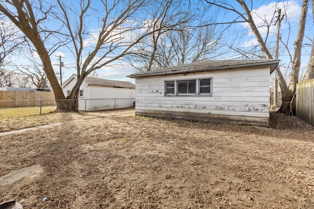 view of front of property featuring a fenced backyard and an outbuilding