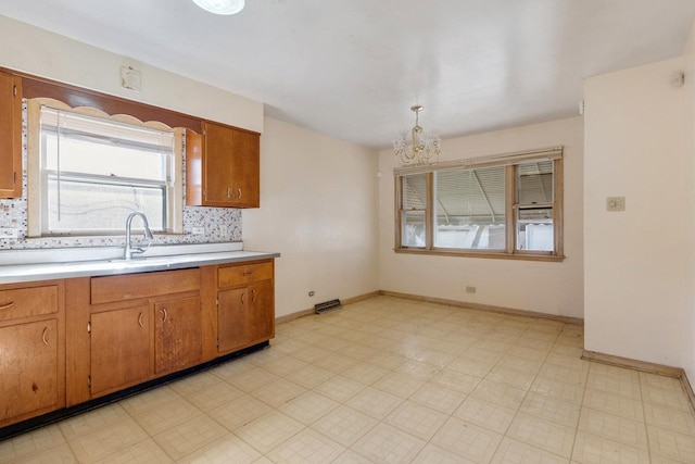 kitchen with light floors, tasteful backsplash, brown cabinetry, and light countertops