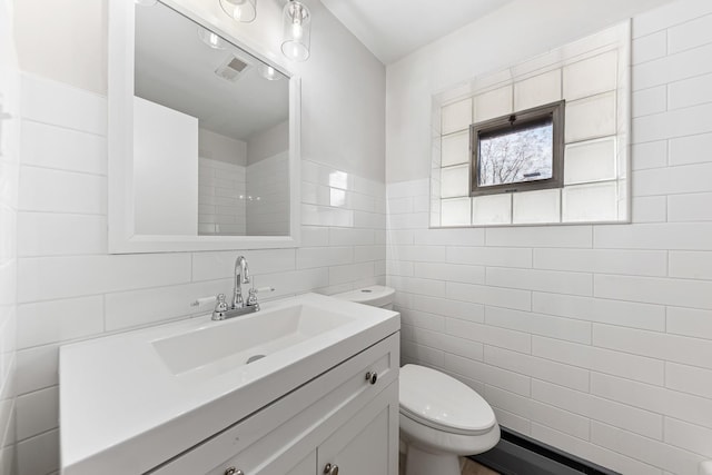 bathroom featuring visible vents, tile walls, toilet, and vanity