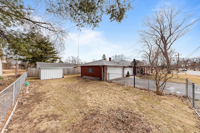 view of yard with a garage, an outdoor structure, and a fenced backyard