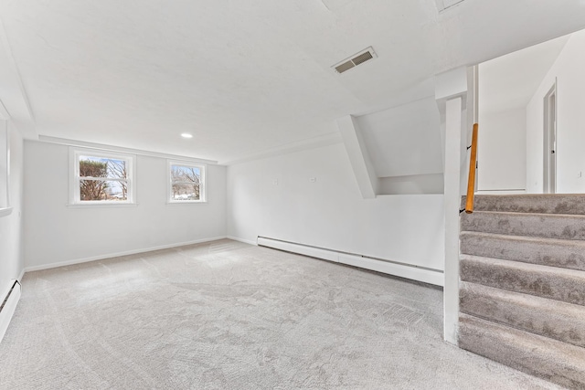 empty room with carpet, a baseboard radiator, visible vents, stairway, and baseboards