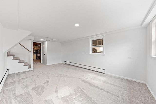 basement featuring baseboards, light colored carpet, a baseboard radiator, stairs, and a baseboard heating unit